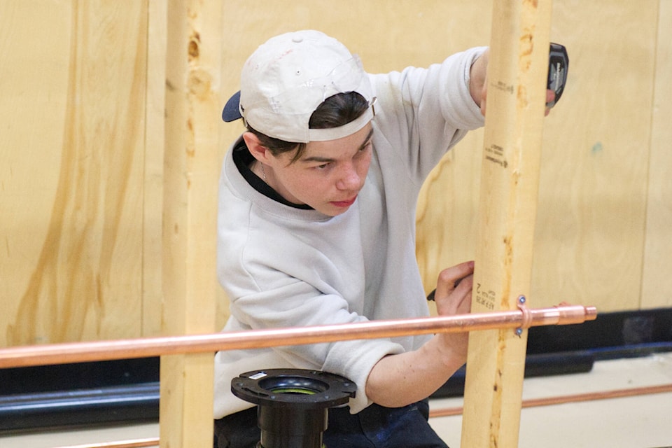 Justin Ekholm works on simulated half-bathroom fitting during the Skills Canada plumbing competition and demonstration held at Yukon University on April 20. (Jim Elliot/Yukon News)