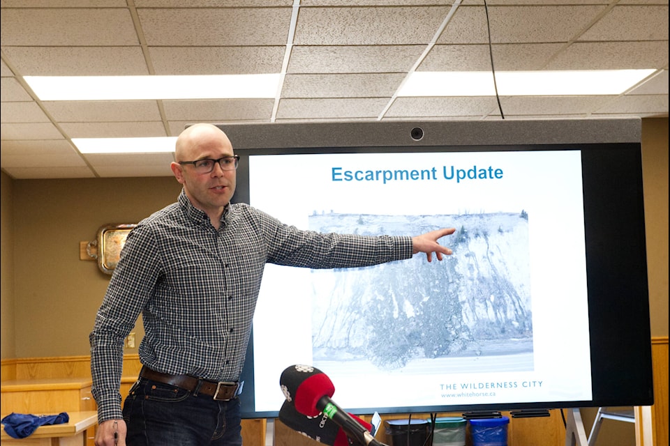 City of Whitehorse engineering manager Taylor Eshpeter discusses plans to mechanically remove concerning portions of the escarpment overlooking Robert Service Way on May 1. (Jim Elliot/Yukon News)